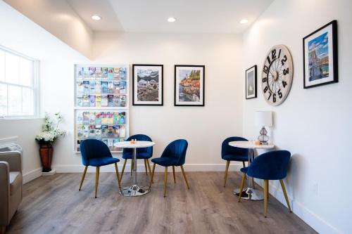 a waiting room with two tables and blue chairs at Seasider Motel in Bar Harbor