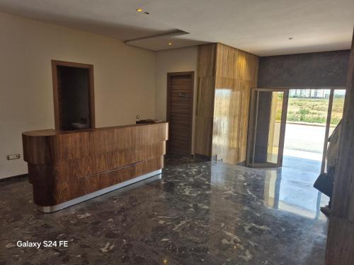 a living room with a large wooden cabinet and marble floor at aeroperla 11 aeroprt casa blanca in Nouaseur