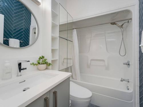 une salle de bain avec un lavabo, des toilettes et un miroir dans l'établissement Old Town Retreat-your artful escape in Victoria’s historic Old Town by Victoria Prime!, à Victoria