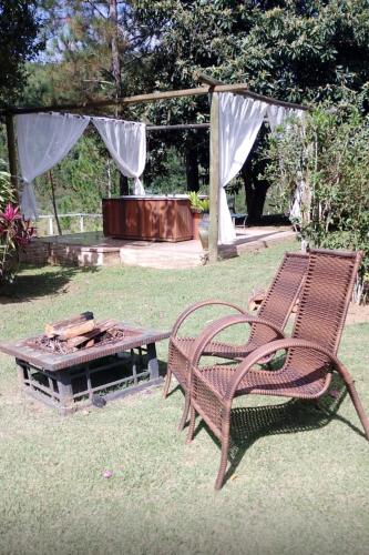 a picnic table and a bench in a yard at Pousada Jupter in Teresópolis