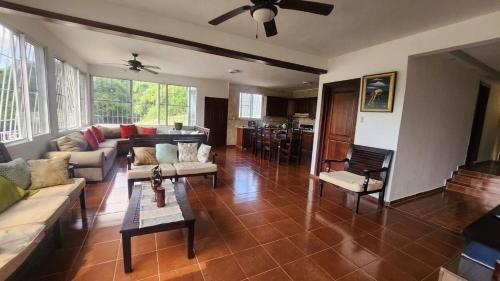 ein Wohnzimmer mit Sofa und Tisch in der Unterkunft Essential Life La Cuaba Casa de Campo Amenities in Pedro Brand