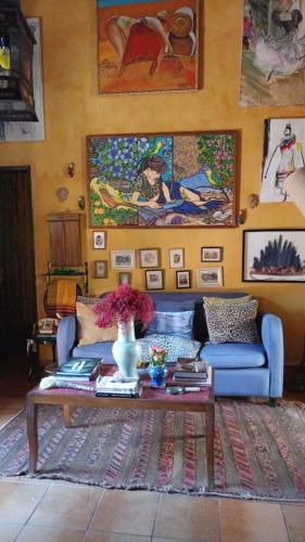 a living room with a blue couch and a table at Vila Santa Rosa Guest House in Ilhabela