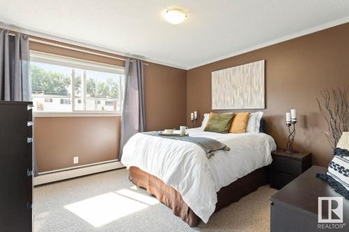 a bedroom with a large bed and a window at Condo Unit-UofA, UofA Hospital, Whyte Ave, Trails! in Edmonton