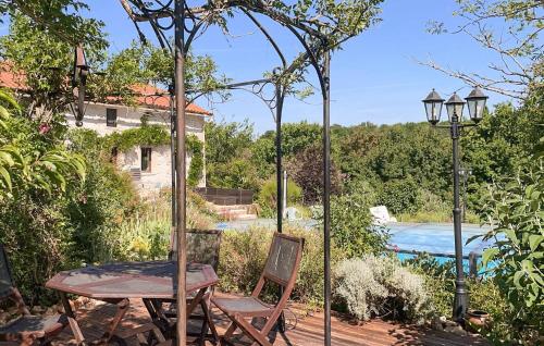 a patio with a table and chairs and a pool at Charmante Maison Avec Piscine in Lizant