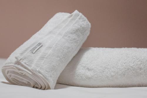 a pile of white towels sitting on a table at Petra Luxury Rooms and Apartments in Korinthos