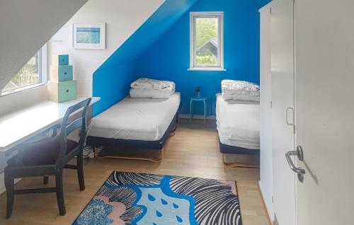 a room with two beds and a blue wall at Amazing Home In Glesborg With Wifi in Glesborg