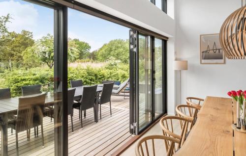 a dining room with sliding glass doors and a table and chairs at Amazing Home In Rødby With Sauna in Rødby