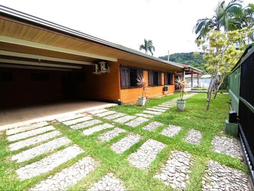 a house with a grassy yard next to a building at Casa espetacular com 5 quartos 50 metros do mar in Matinhos