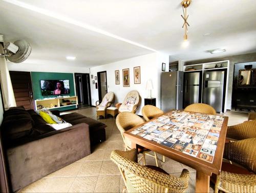 a living room with a table and a couch at Casa espetacular com 5 quartos 50 metros do mar in Matinhos