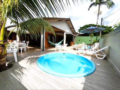a large blue tub on a patio with a table and chairs at Casa espetacular com 5 quartos 50 metros do mar in Matinhos