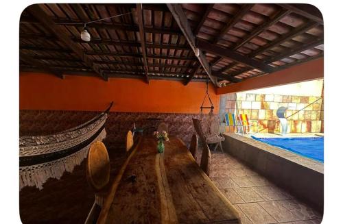 a long wooden table in a room with a bed at Residencial Divina in Pirenópolis