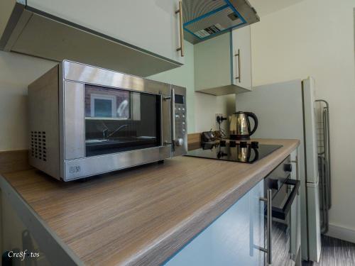 a microwave oven sitting on top of a kitchen counter at Newlands Lodge Deluxe Family Room 2 in Stoke on Trent