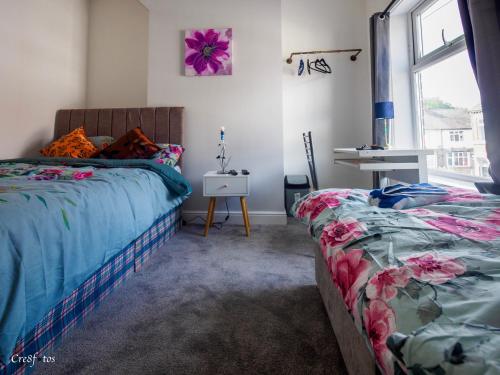 a bedroom with two beds and a window at Newlands Lodge Deluxe Family Room 2 in Stoke on Trent