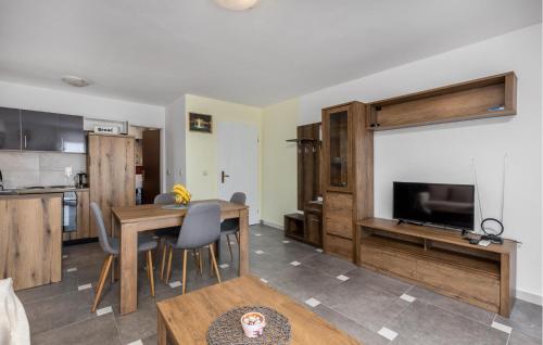 a kitchen and living room with a table and a television at Nice Apartment In Barbat With Wifi in Barbat na Rabu