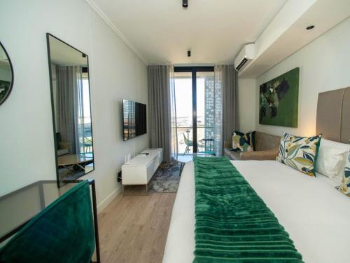 a bedroom with a large bed and a living room at Beautiful Garnet at Ellipse in Midrand