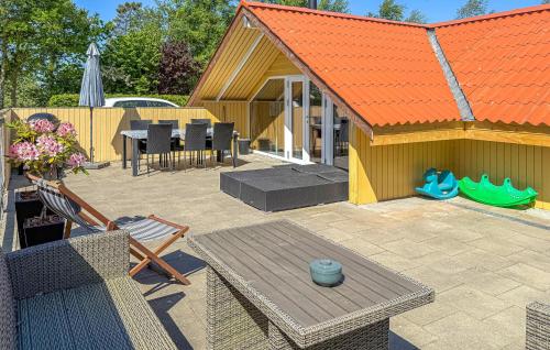 a patio with an orange roof and a table and chairs at Holiday Home Fjordparken Hadsund Iii in Odde