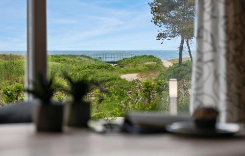 a view of the ocean from a room with a window at Holiday Home Skovbrynet Tarm V in Hemmet