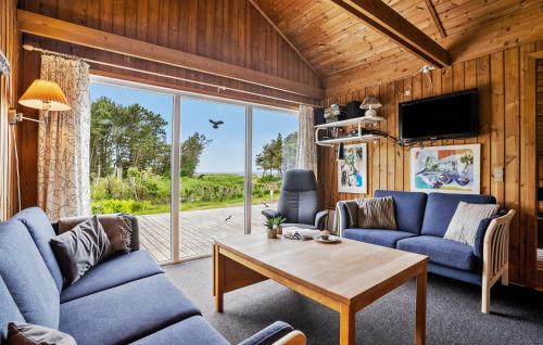 a living room with blue couches and a table at Holiday Home Skovbrynet Tarm V in Hemmet