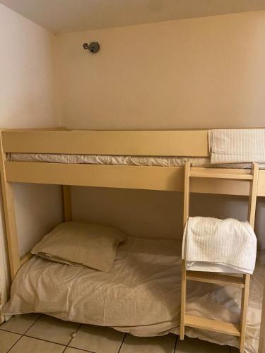 un lit superposé dans une pièce avec une échelle et une étagère dans l'établissement Studio 50M de la mer, à Saint-Laurent-du-Var
