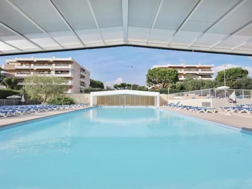 une grande piscine avec des chaises et un bâtiment dans l'établissement Studio 50M de la mer, à Saint-Laurent-du-Var