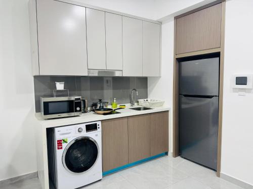 a kitchen with a washing machine and a microwave at My Service Suites Agile KL in Kuala Lumpur