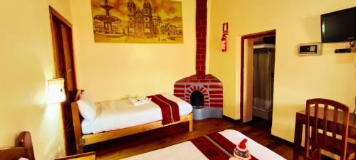 a bedroom with a bed and a fireplace at Amankay Inn in Cusco
