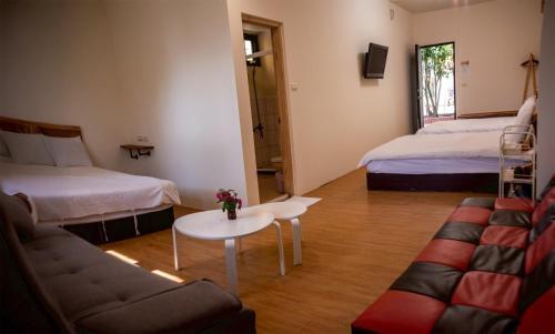 a room with two beds and a couch and a table at Nantou Fruit House in Renai