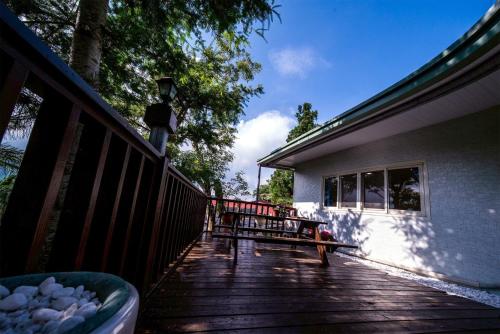 a wooden deck with a bench on a house at Nantou Fruit House in Renai