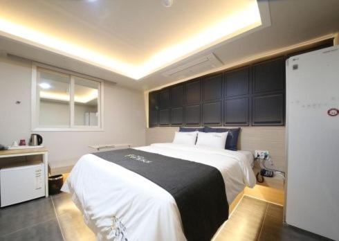a bedroom with a large bed with a black and white blanket at Gwangju Yeogijoa Hotel in Gwangju