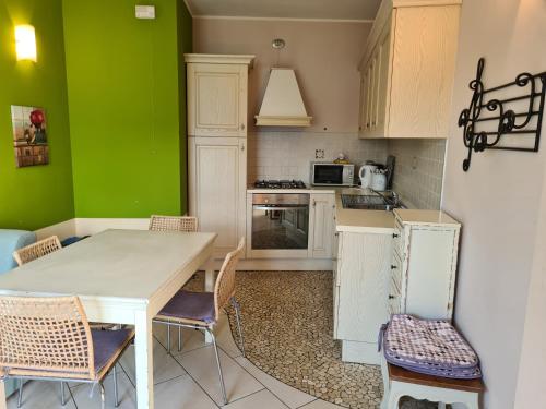 a kitchen with green walls and a table and chairs at Residence Giglio Comer See in Gravedona