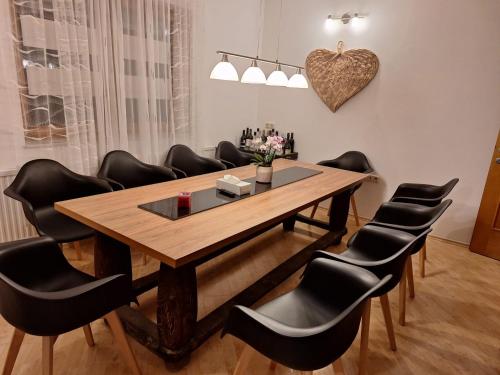 a conference room with a wooden table and black chairs at Villa Shakira in Zissersdorf