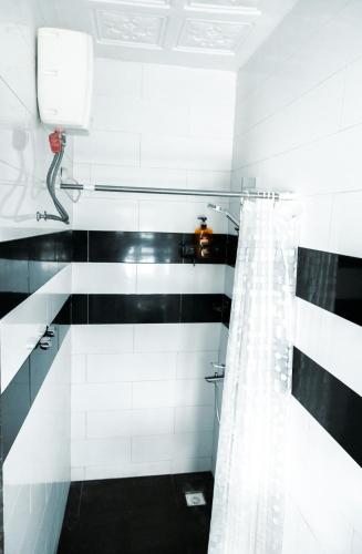 a black and white bathroom with a shower curtain at The Space in Adentan