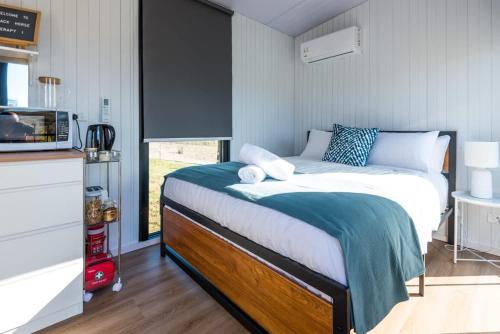 a small bedroom with a bed in a kitchen at Black Horse Cabin 1 by Tiny Away in Parakakau