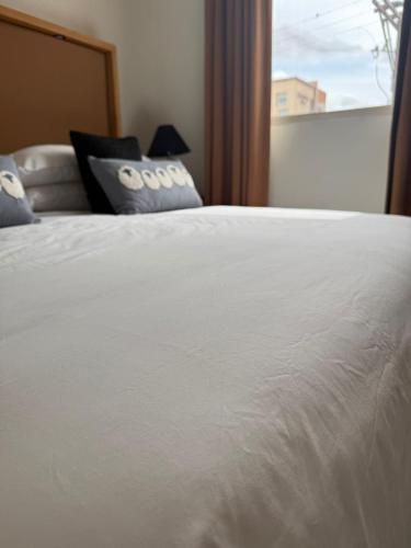 a white bed with a pillow and a window at Unicorn Zebra in Tucson