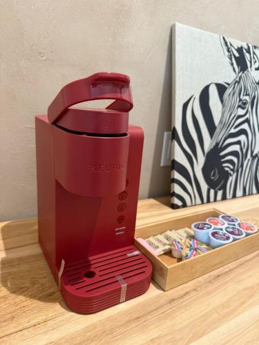 a red coffee maker sitting on top of a table at Unicorn Zebra in Tucson