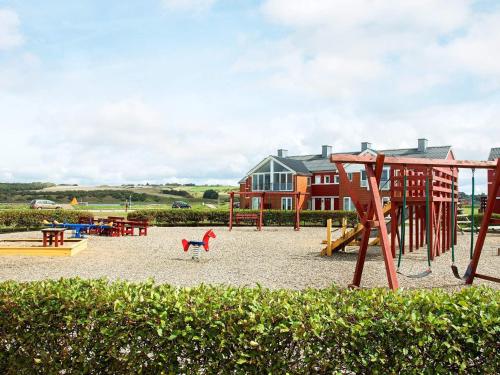 a playground with a slide and a swing set at 5 person holiday home on a holiday park in Lemvig in Lemvig
