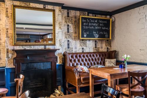 a restaurant with a bench and a table and a mirror at The Bulls Head Hotel in Bromley