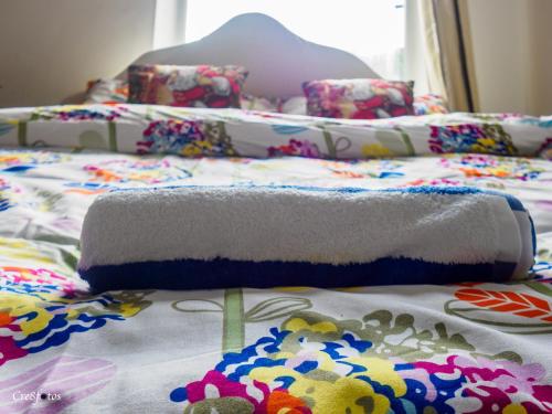 a bed with a blanket and pillows on it at Newlands Lodge Deluxe Family Room 3 in Stoke on Trent
