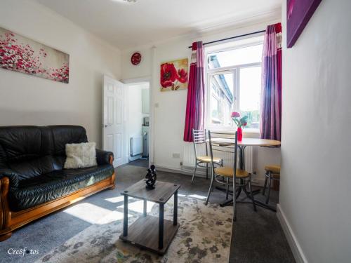 a living room with a couch and a table at Newlands Lodge Deluxe Family Room 3 in Stoke on Trent