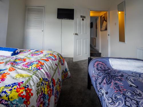 Un pat sau paturi într-o cameră la Newlands Lodge Deluxe Family Room 3