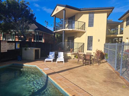 a house with a swimming pool in front of a house at Sawtell Motor Inn in Sawtell