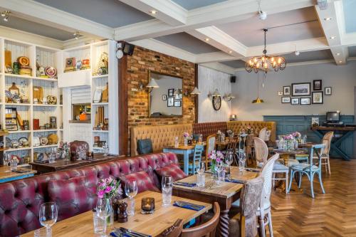 a restaurant with wooden tables and red leather seats at The Bulls Head Hotel in Bromley