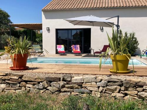 une maison avec une piscine et un parasol dans l'établissement Villa in Sainte Valière with Private Pool, à Sainte-Vallière