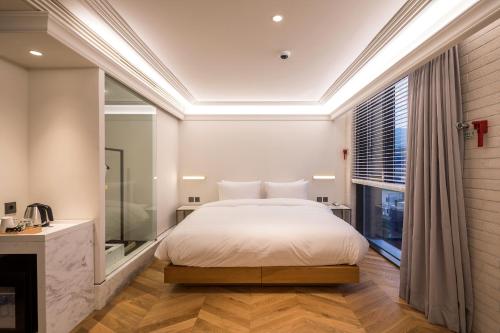 a bedroom with a bed and a large window at Cont Hotel in Busan