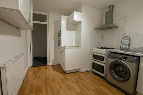 a kitchen with a washing machine and a washer at 3 Bed Stylish & Spacious Home, Sleep up to 7ppl in Portsmouth
