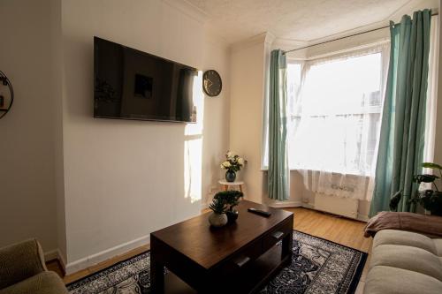 a living room with a couch and a table at 3 Bed Stylish & Spacious Home, Sleep up to 7ppl in Portsmouth