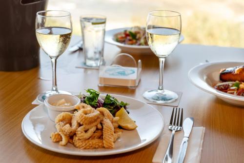 a table with plates of food and glasses of wine at Pacific Hotel Yamba in Yamba