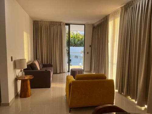 a living room with a couch and chairs and a window at Villas Solemar, Aticama in Aticama