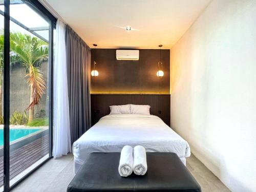a bedroom with a bed and a swimming pool at Villa Shinta1 with 3 BR, Pool & WiFi in Ungasan Bali by Damaresa in Uluwatu