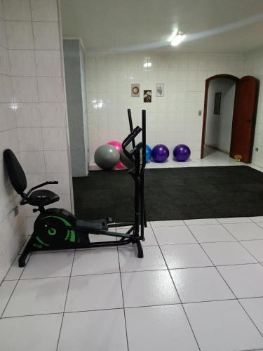a room with a gym with a treadmill and balls at Suíte no Morumbi in Sao Paulo
